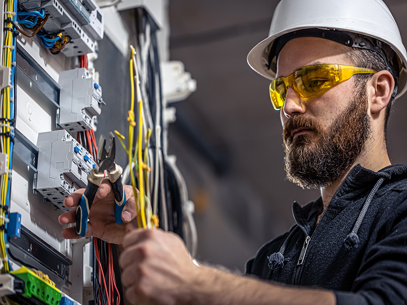 Un technicien en train de faire la maintenance d'une armoire électrique